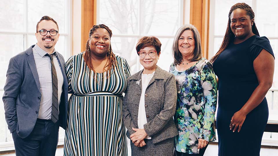 A group of five diversed Tyndale alumni students smiling 