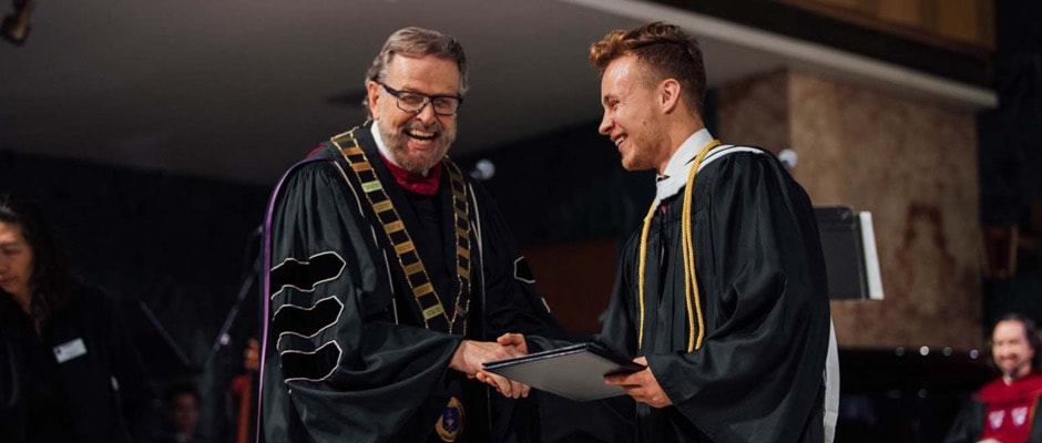 President Nelson presenting the graduation certificate to a graduate