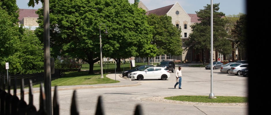 view of the campus from the front lawn through a fence