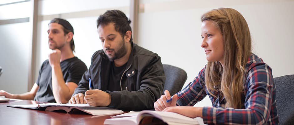 Three students sitting at a desk