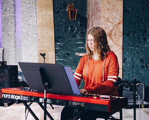 Helen Lawrence playing keyboard on the Chapel stage