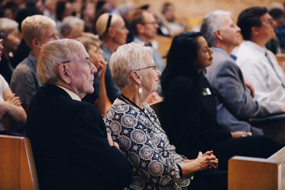 Alumni and staff sitting in crowd