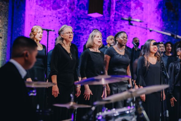 Members of the Tyndale Singers singing behind the drummer