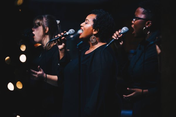 A group of women singing into microphones