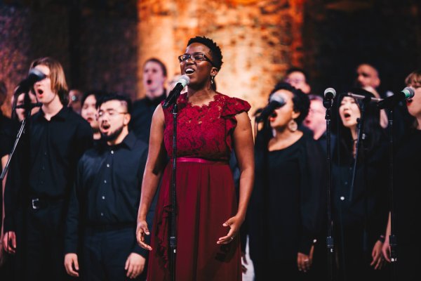 A young woman dressed in red singing 