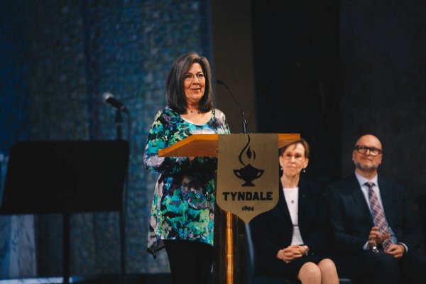 Woman speaks at podium, Lisa Elliott gives speech