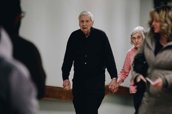 Elderly couples walks inside corridor into Tyndale Chapel holding hands