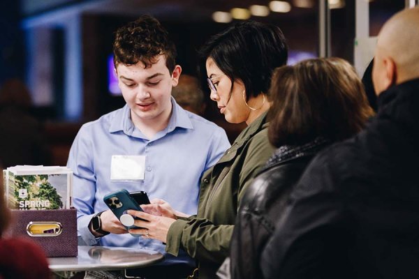 Tyndale student volunteer smiling and scanning ticket at the front entrance of the chapel