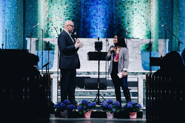 Kevin Kirk and Nadine speaking at centre stage of the chapel