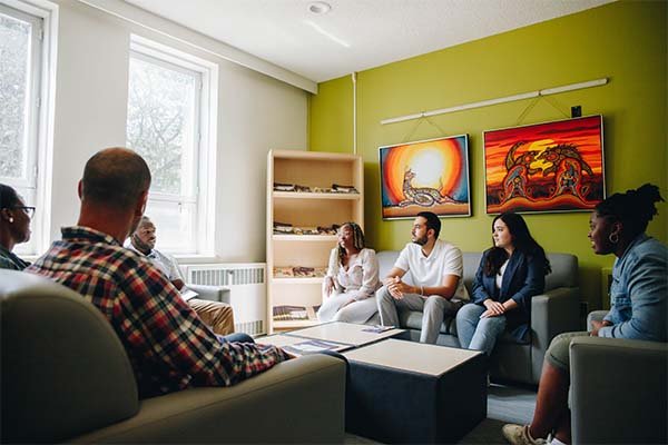 A group of diverse students having a discussion while sitting on lounge chairs