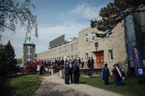 Graduates socializing with other graduates and faculty