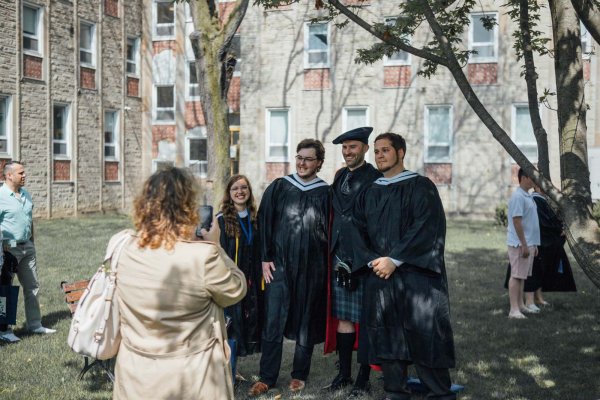 Graduates taking pictures with Dr Benjamin Reynolds