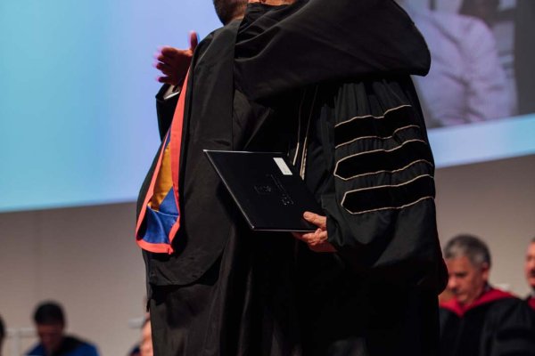 Graduate hugging mentor