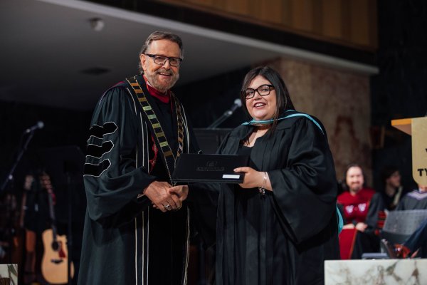 President Gary Nelson presenting a graduation certificate to a Bachelor of Education graduate