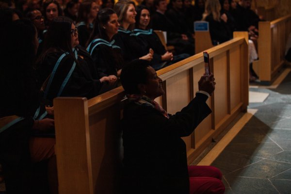 An excited family member of a Bachelor of Education graduate taking picture