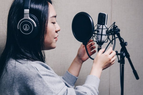 Singer recording voice through microphone